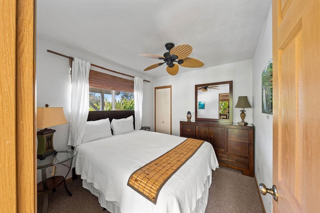 1444 West Kuiaha Road Haiku, HI 96708 - Photo 17 of 30 a bedroom with a bed and a chandelier