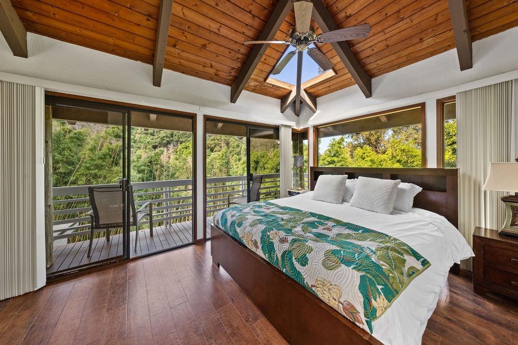 1444 West Kuiaha Road Haiku, HI 96708 - Photo 26 of 30 a bedroom with a bed and wooden floor