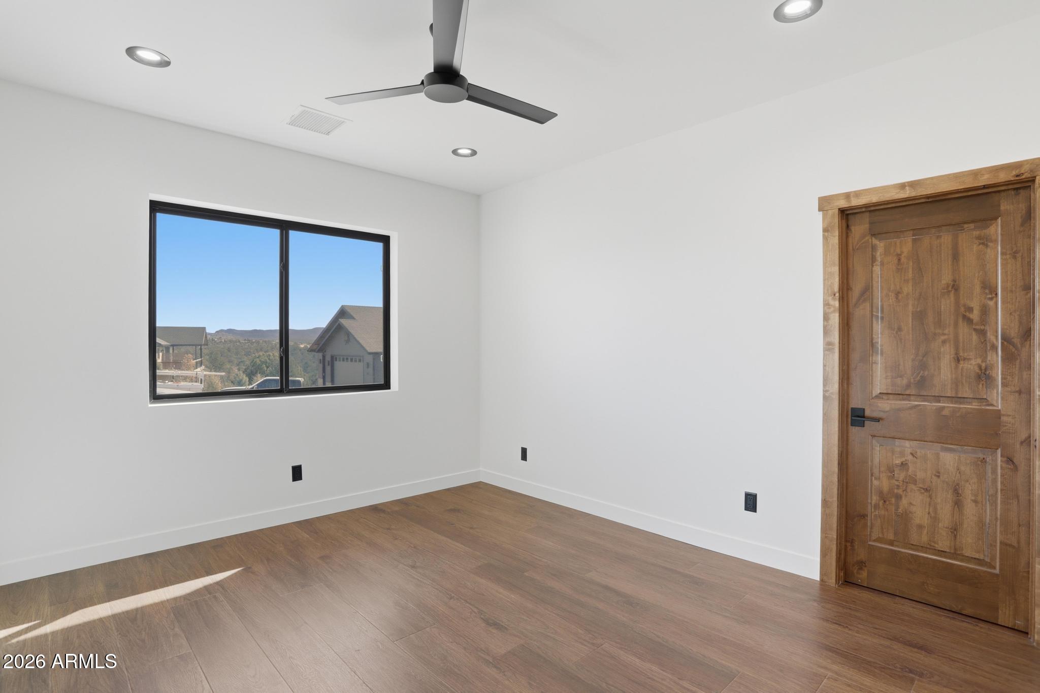 1112 South Kinzer Court Payson, AZ 85541 - Photo 13 of 41 a view of an empty room with wooden floor and a window