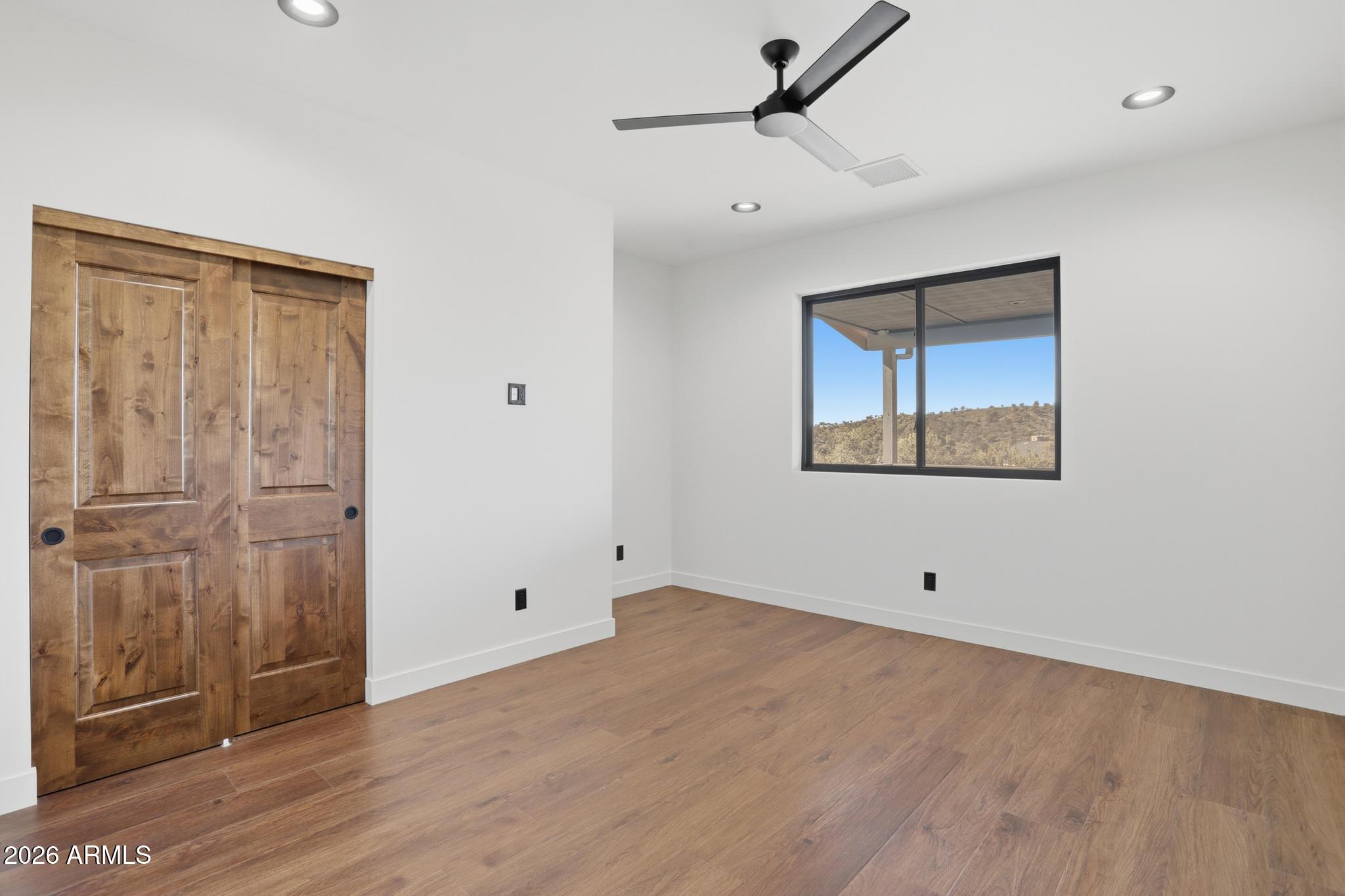 1112 South Kinzer Court Payson, AZ 85541 - Photo 16 of 41 a view of an empty room with wooden floor and a ceiling fan