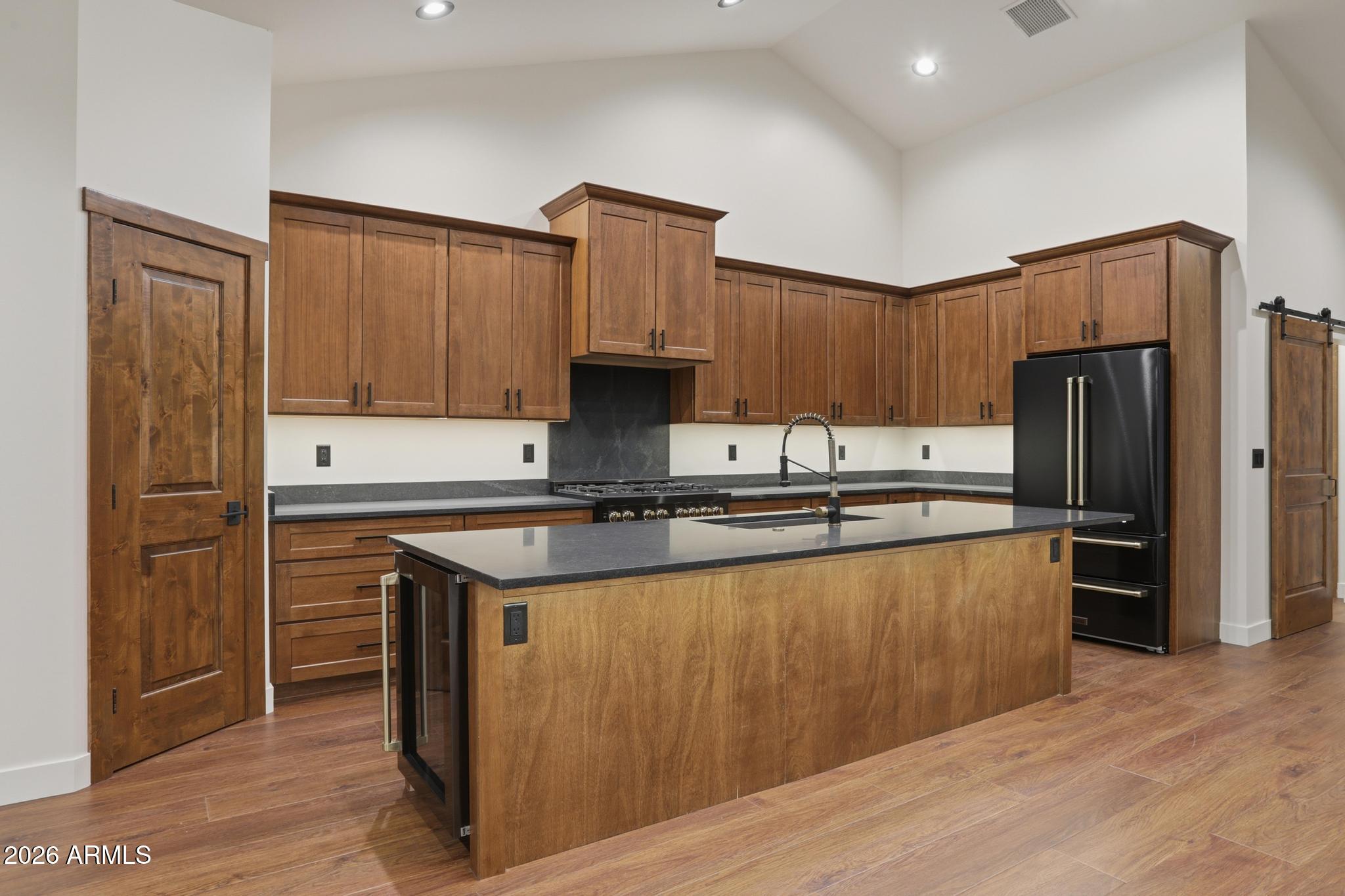 1112 South Kinzer Court Payson, AZ 85541 - Photo 4 of 41 a kitchen with kitchen island granite countertop wooden cabinets a refrigerator and a sink