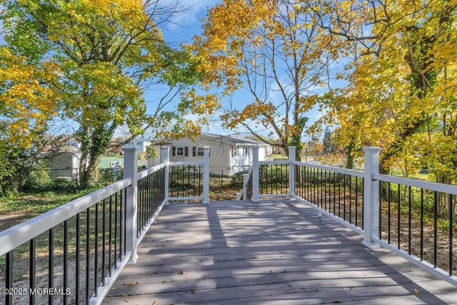 a view of a house with wooden deck next to a yard