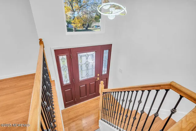 a view of a hallway with wooden floor and stairs
