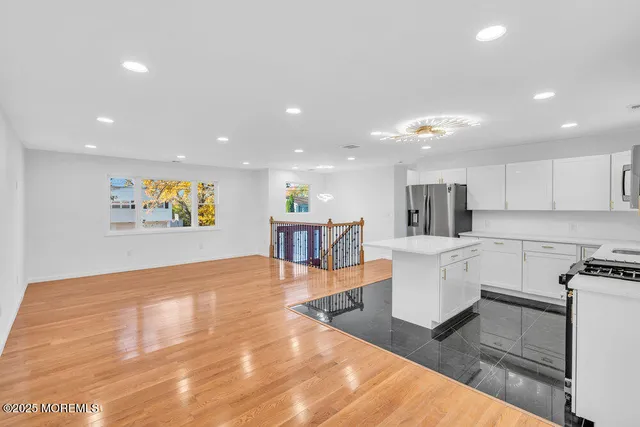a living room with stainless steel appliances furniture and a kitchen view