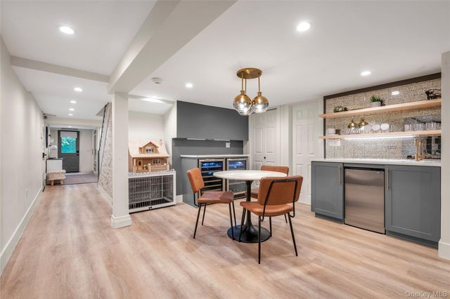 a kitchen with stainless steel appliances kitchen island granite countertop a table chairs sink and cabinets