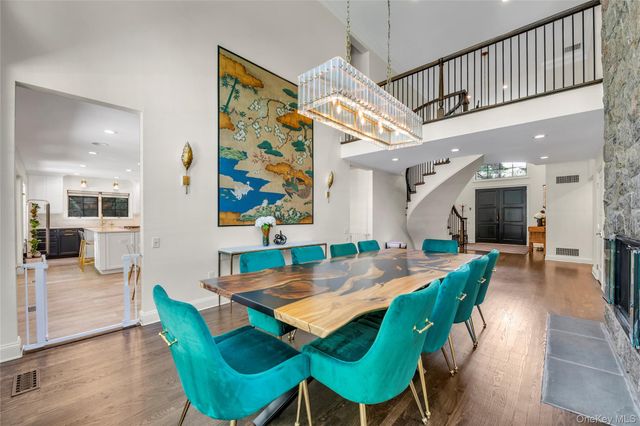 a view of a dining room with furniture a chandelier and wooden floor