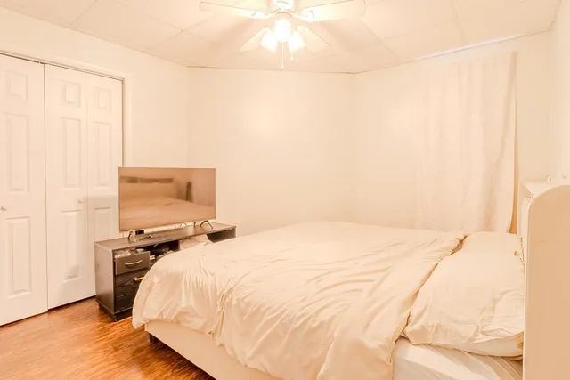 a bedroom with a bed and wooden floor