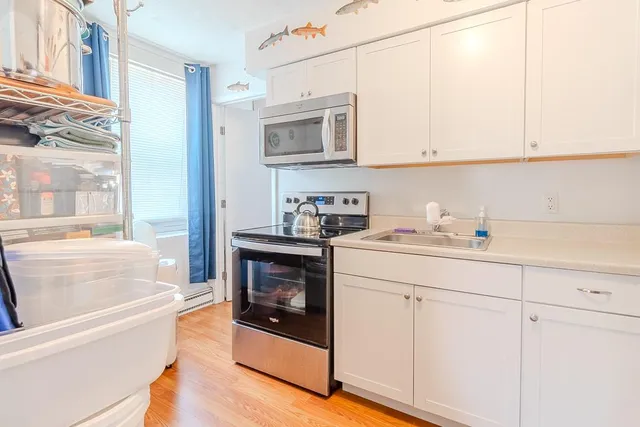 a kitchen with white cabinets and a sink