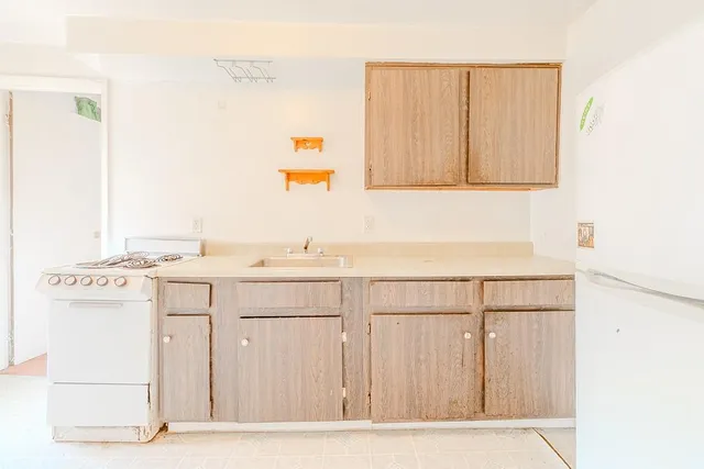 a room with a sink cabinets and a window