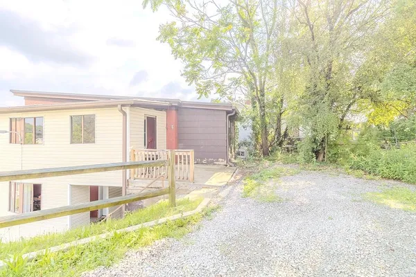 a view of a house with backyard and a tree