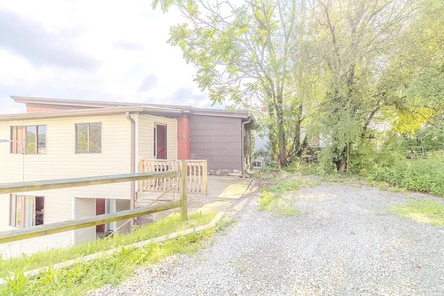 a view of a house with backyard and a tree
