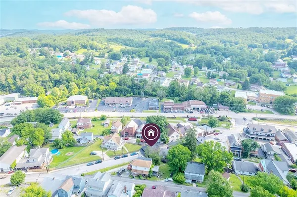an aerial view of residential houses with outdoor space and parking