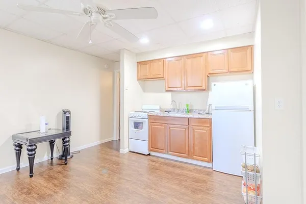 a kitchen with granite countertop a refrigerator a sink a stove a dining table and chairs