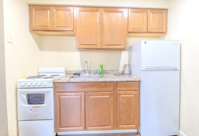a kitchen with stainless steel appliances granite countertop a refrigerator and a stove
