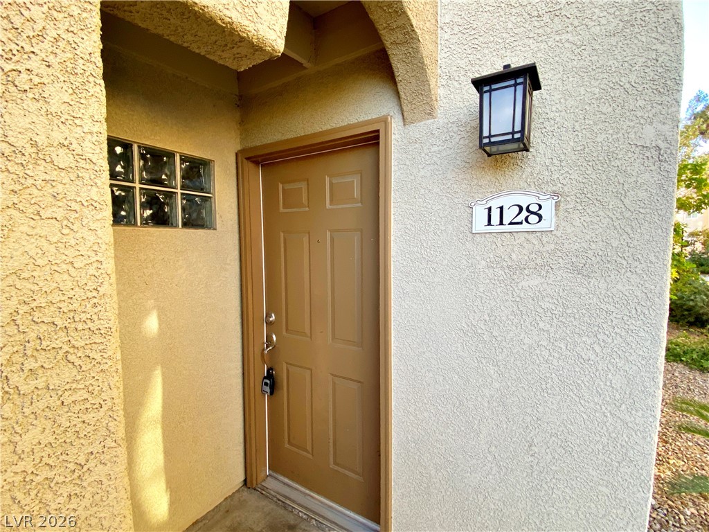 3145 East Flamingo Road, Unit 1128 Las Vegas, NV 89121 - Photo 2 of 19 A welcoming entry invites with a panel door and illuminating wall sconce.