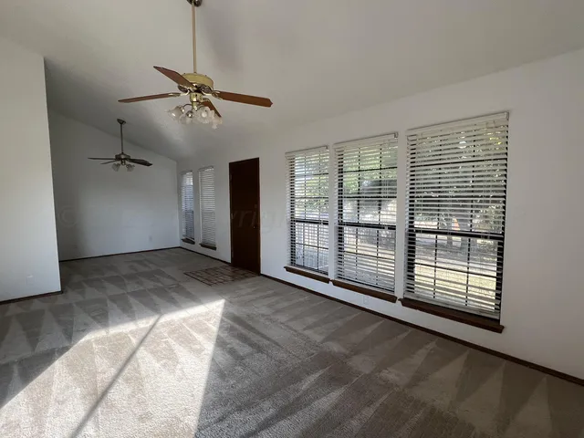 a view of a livingroom with a ceiling fan and window
