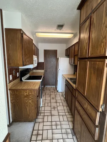 a kitchen with stainless steel appliances granite countertop a refrigerator and a stove