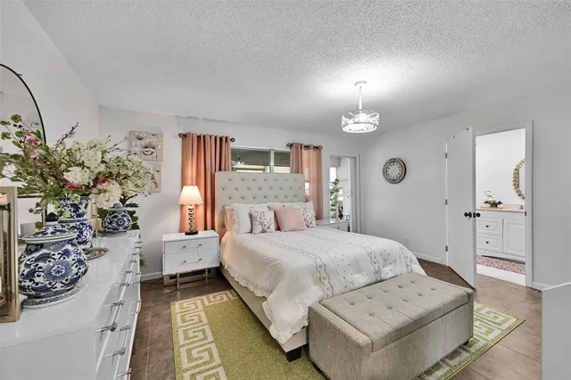 a bedroom with a large bed and a chandelier