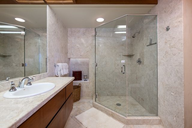 a bathroom with a sink shower and a mirror