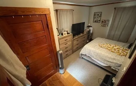 a bedroom with a bed and a flat tv screen on the dresser