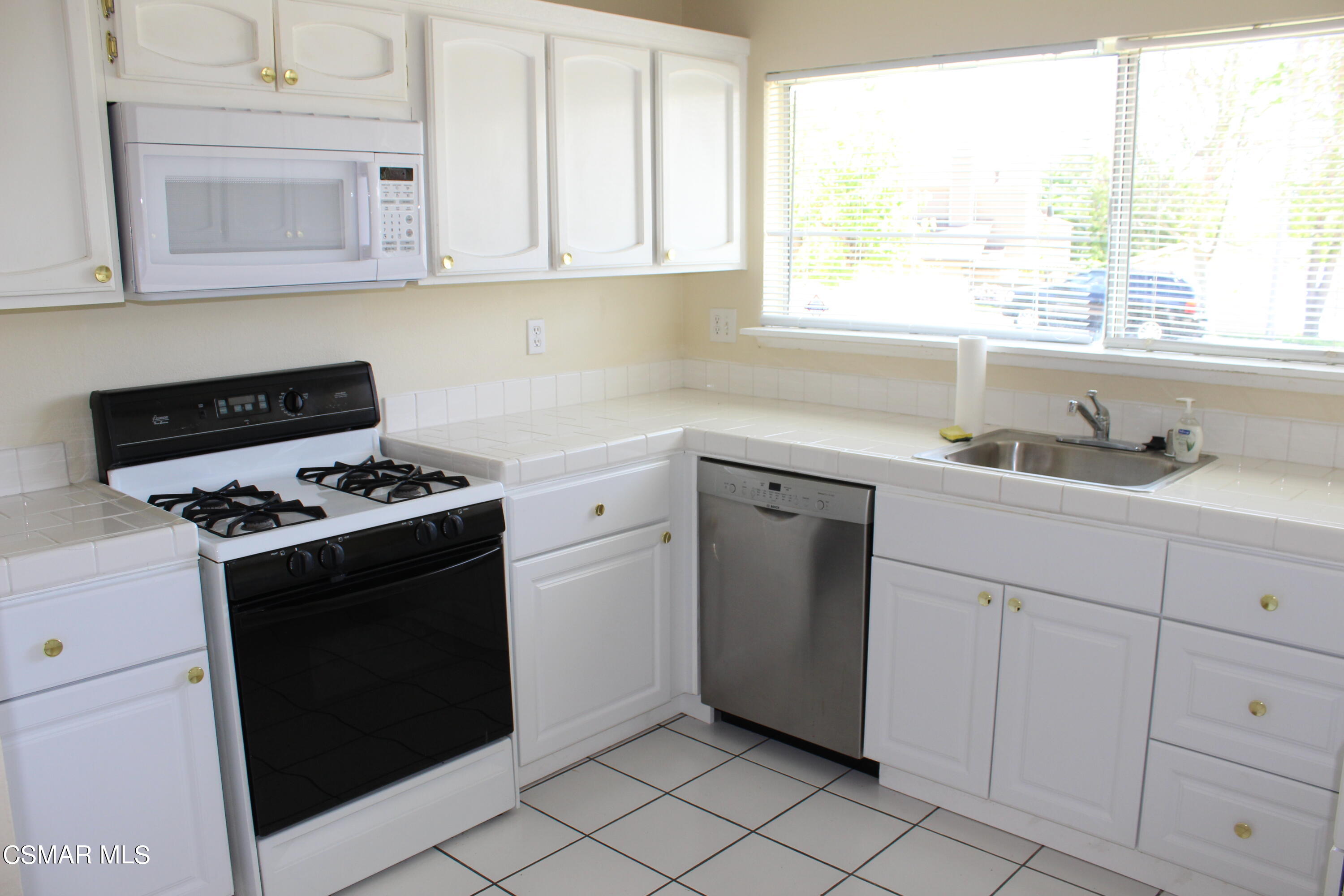 15063 Reedley Street Moorpark, CA 93021 - Photo 3 of 18 a kitchen with granite countertop cabinets stainless steel appliances and a window