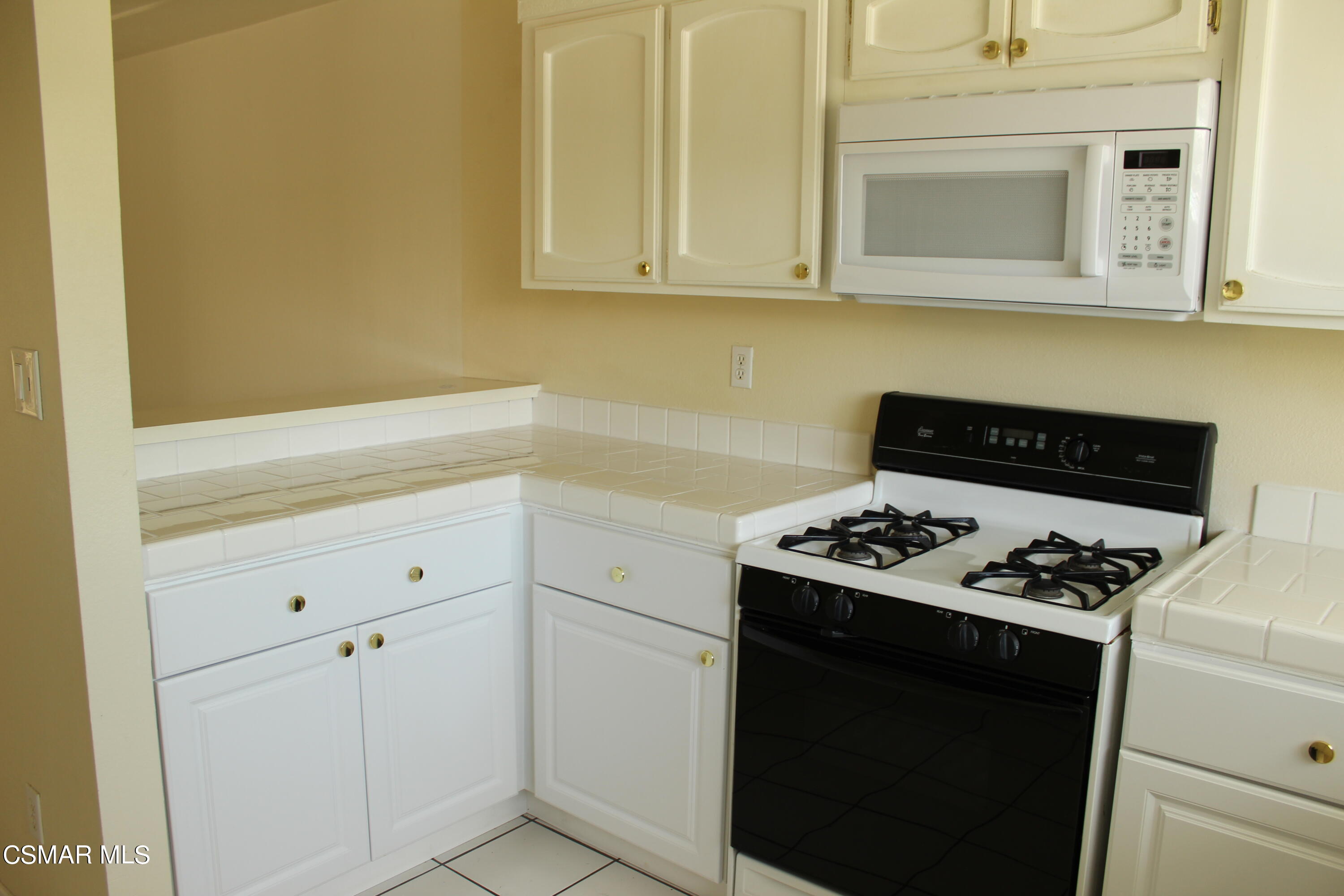15063 Reedley Street Moorpark, CA 93021 - Photo 4 of 18 a kitchen with white cabinets and appliances