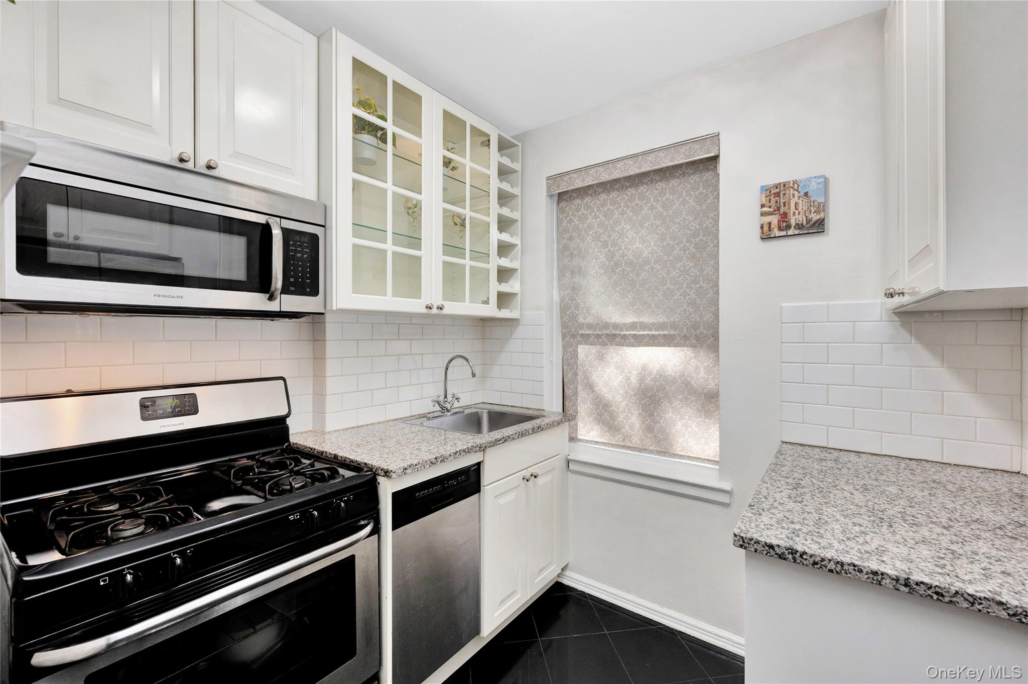 141-42 78th Road, Unit 1D Queens, NY 11367 - Photo 8 of 15 a kitchen with stainless steel appliances granite countertop a stove and a microwave