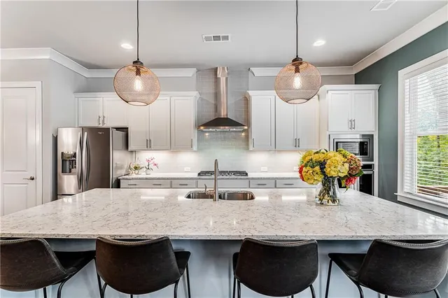 a kitchen with stainless steel appliances granite countertop a table chairs and a chandelier