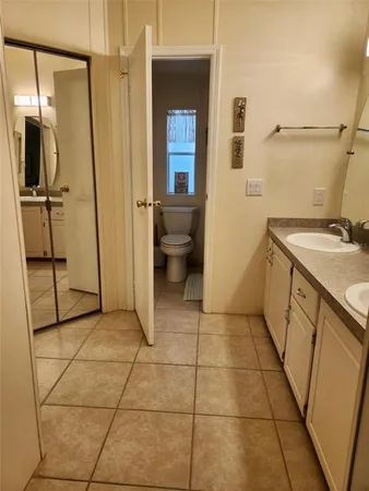 a bathroom with a granite countertop sink a mirror and shower