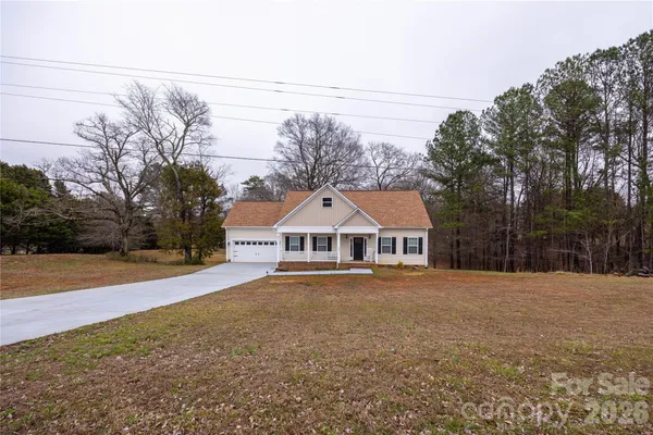 a front view of a house with a yard and trees