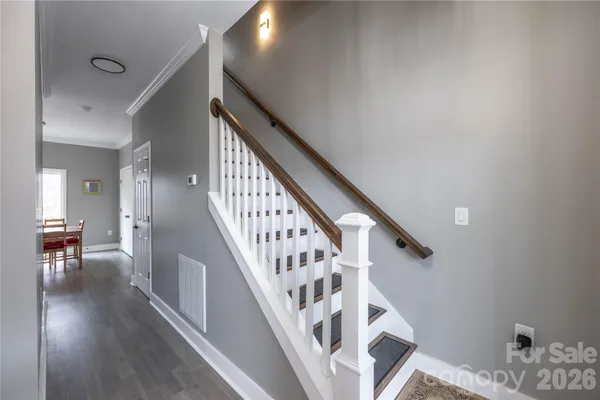 a view of staircase with wooden floor and a chandelier