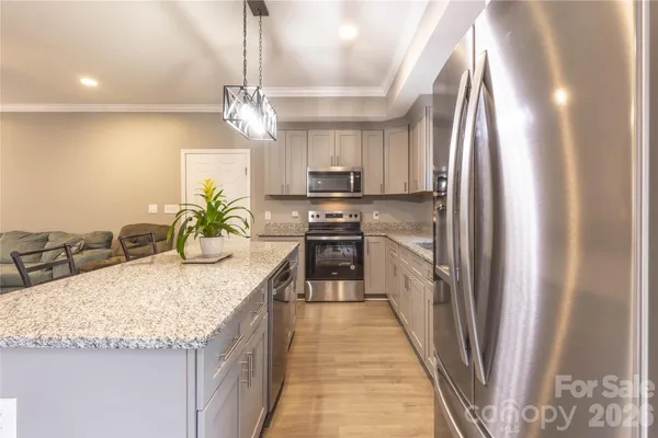 a kitchen with stainless steel appliances granite countertop sink stove and refrigerator