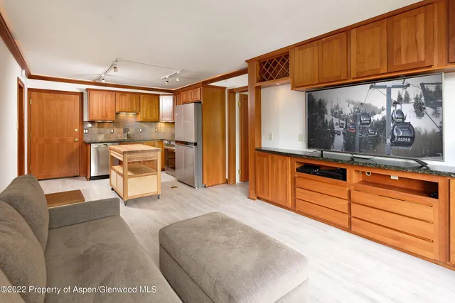 a living room with stainless steel appliances kitchen island granite countertop furniture and a window