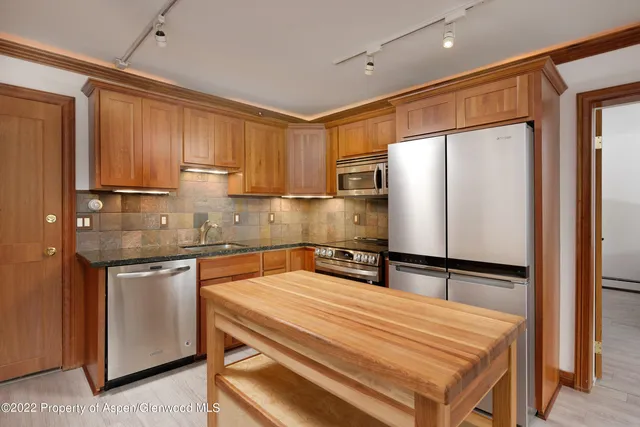 a kitchen with stainless steel appliances granite countertop a refrigerator sink and cabinets
