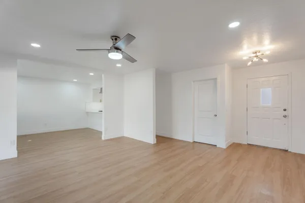 a view of an empty room and a kitchen