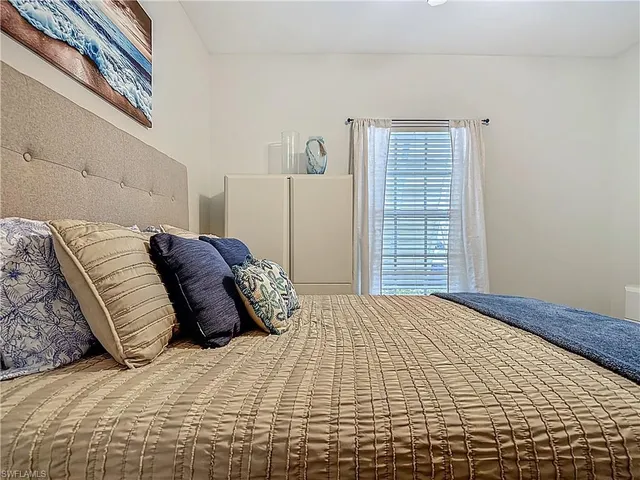 a bedroom with a large bed and a window