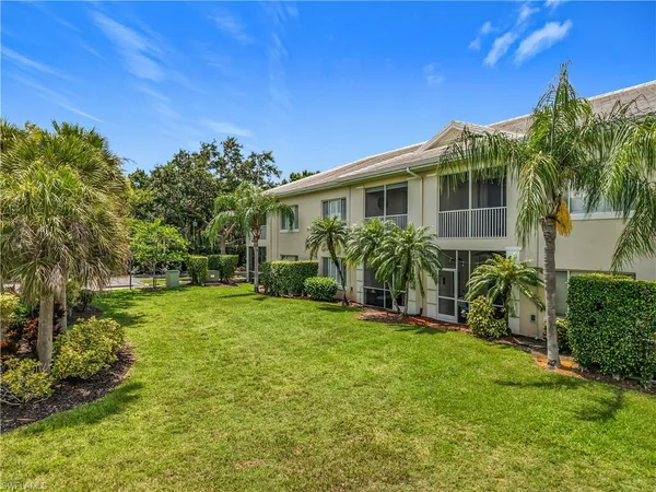 a front view of a house with a yard and potted plants
