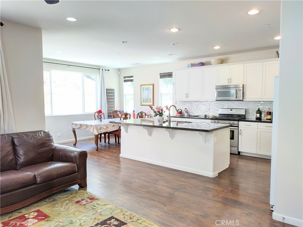 11811 Cramer Road Yucaipa, CA 92399 - Photo 15 of 56 a living room with kitchen furniture and a wooden floor