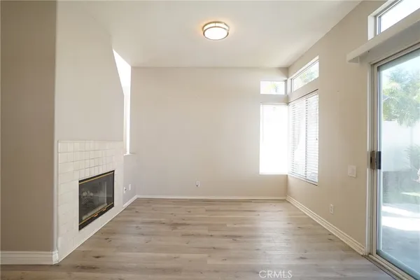 a view of empty room with wooden floor and fireplace
