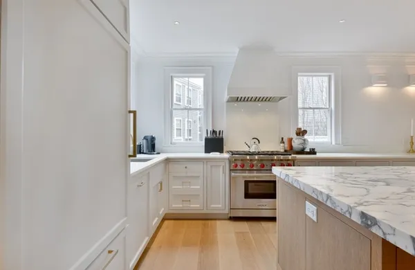 a kitchen with stainless steel appliances granite countertop a stove and white cabinets