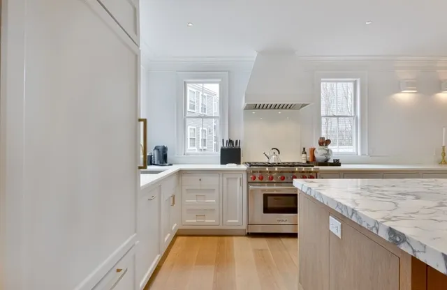 a kitchen with stainless steel appliances granite countertop a stove and white cabinets
