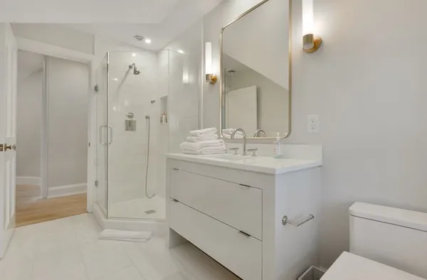 a bathroom with a sink a toilet and shower