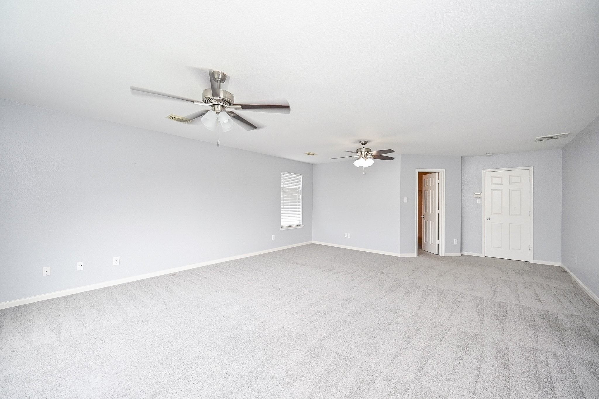 6638 Autumn Sunset Lane Spring, TX 77379 - Photo 18 of 32 Spacious and bright primary bedroom with modern ceiling fans and ample natural light. Ideal for relaxation and comfort.