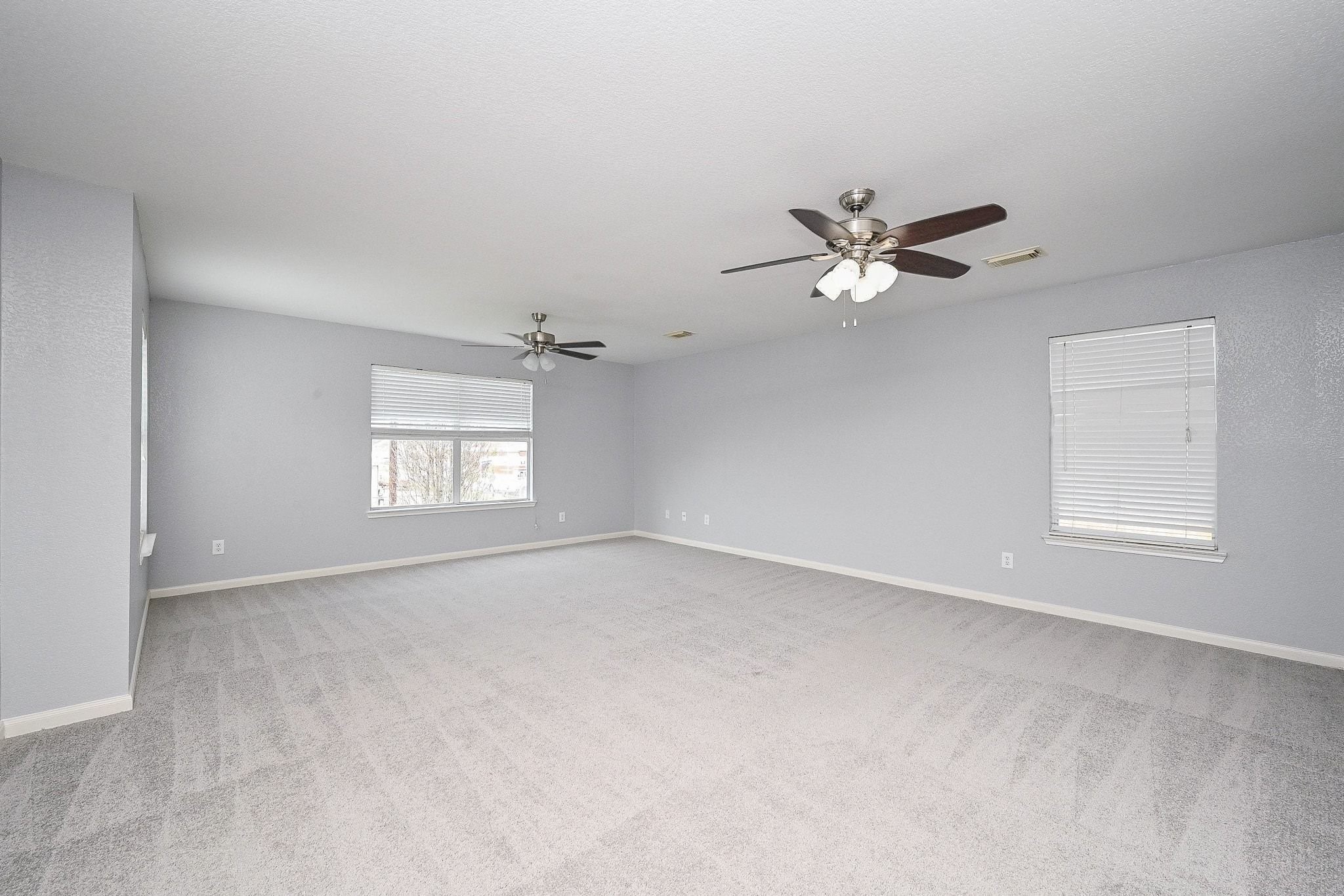 6638 Autumn Sunset Lane Spring, TX 77379 - Photo 19 of 32 Spacious primary bedroom with abundant natural light and modern ceiling fans.