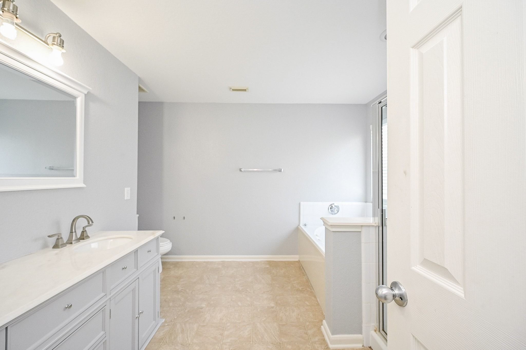 6638 Autumn Sunset Lane Spring, TX 77379 - Photo 21 of 32 Bright and spacious bathroom featuring a dual-sink vanity, elegant fixtures, and a relaxing bathtub, perfect for unwinding.