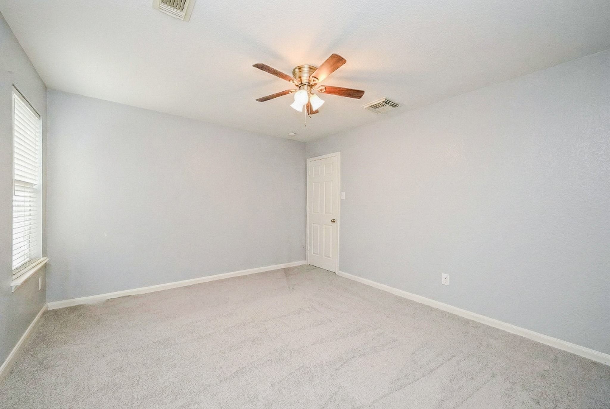 6638 Autumn Sunset Lane Spring, TX 77379 - Photo 28 of 32 Spacious and bright, this versatile bedroom offers a cozy retreat with a ceiling fan and soft carpeting, perfect for relaxation.