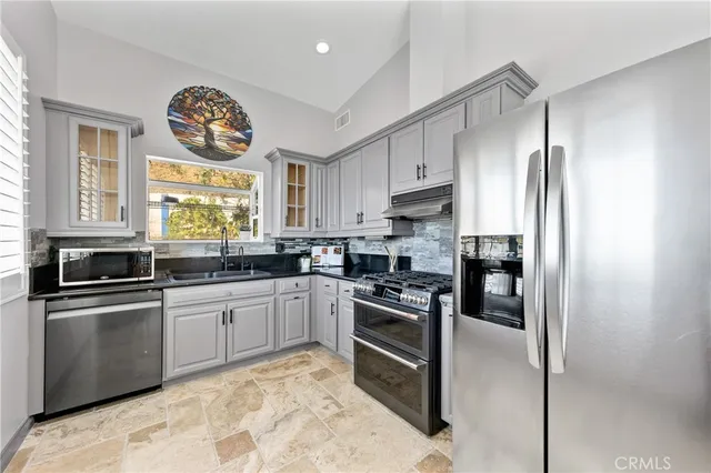 a kitchen with granite countertop cabinets and steel stainless steel appliances