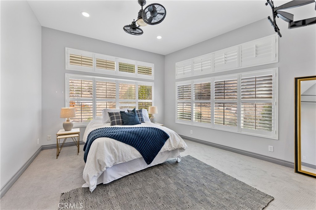 591 Devonwood Road Altadena, CA 91001 - Photo 20 of 35 a spacious bedroom with a bed a chandelier and a window