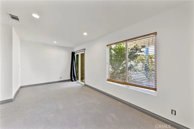 an empty room with closet and windows