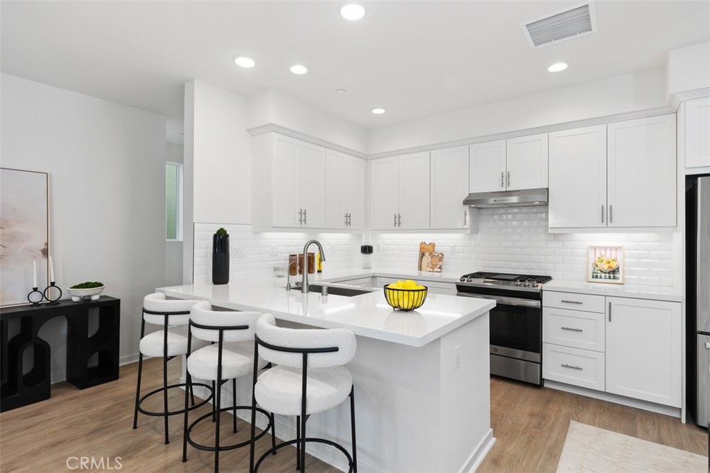 155 Fable Irvine, CA 92618 - Photo 11 of 41 a kitchen with a sink a stove a dining table and chairs